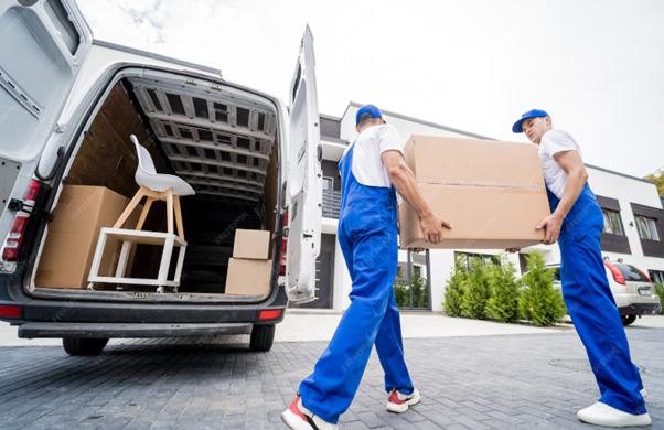 Two movers carrying a large box into a white moving van